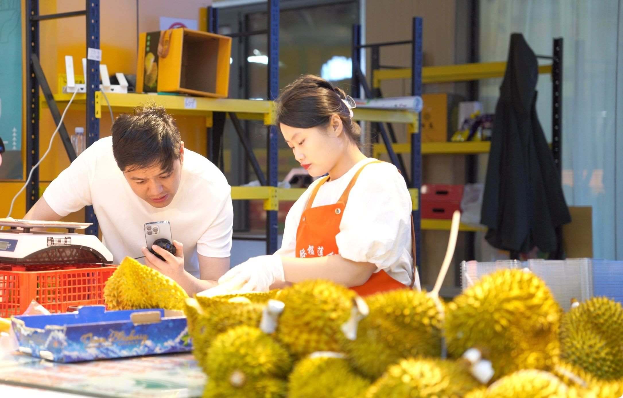 榴蓮商家正在通過(guò)手機(jī)直播銷(xiāo)售榴蓮。人民網(wǎng)記者申佳平 攝