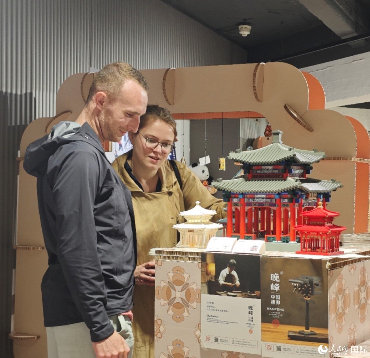 英國觀眾在欣賞中國傳統(tǒng)榫卯結構建筑模型。邢雪攝