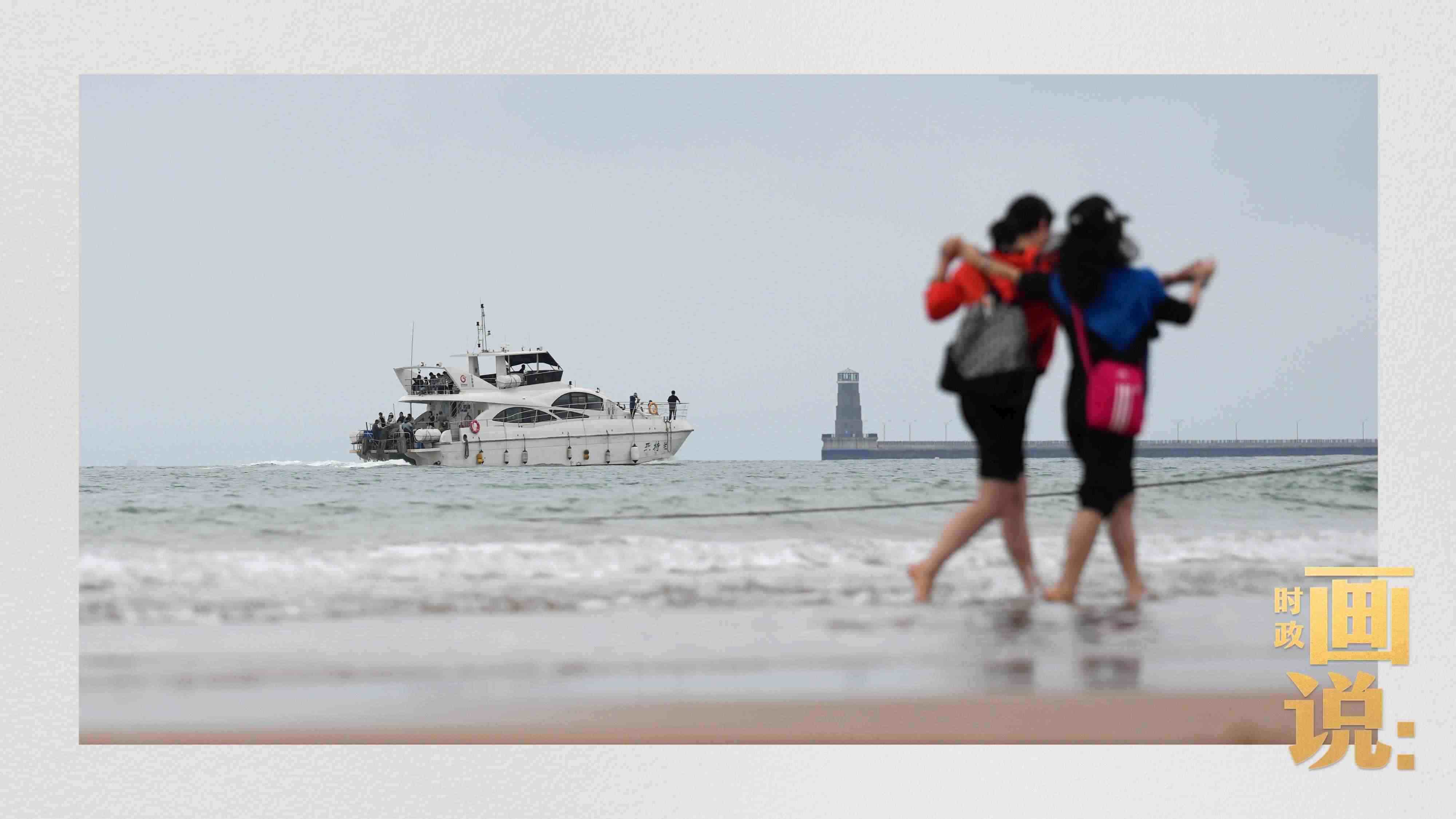 △日照陽(yáng)光海岸綠道上的萬(wàn)平口景區(qū)，一對(duì)游客在海浪中翩然起舞。