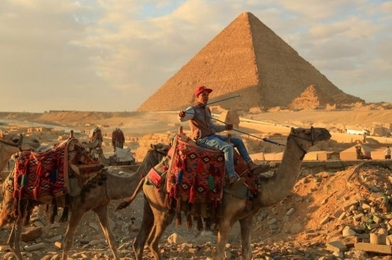 1月24日，商販騎駱駝離開埃及吉薩金字塔景區(qū)。新華社記者 隋先凱 攝