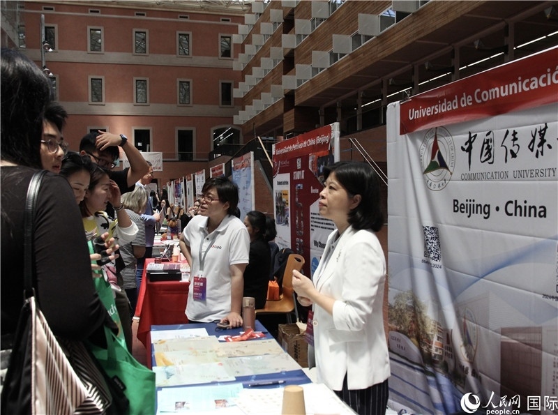 旅西華人華僑在展臺前咨詢。人民網(wǎng)記者 許海林?jǐn)z