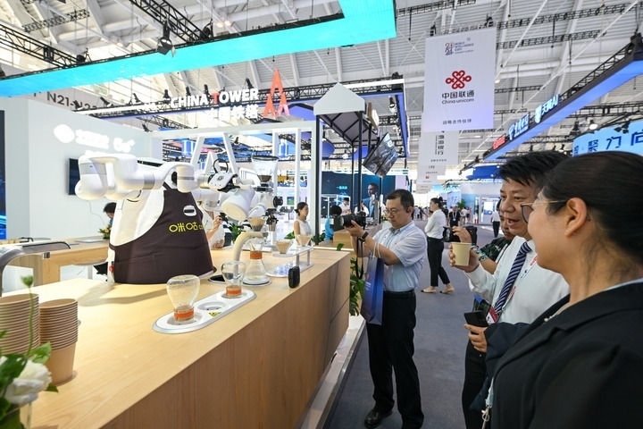 6月20日，與會(huì)者品嘗機(jī)器人沖調(diào)出的咖啡。新華社記者 孫凡越 攝