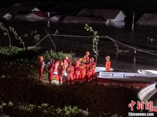  7月6日凌晨3時，在湖南岳陽華容縣團洲垸洞庭湖一線堤防，救援人員剛剛完成一次救援任務，遠處是被淹的民房。中新社記者 白祖偕 攝