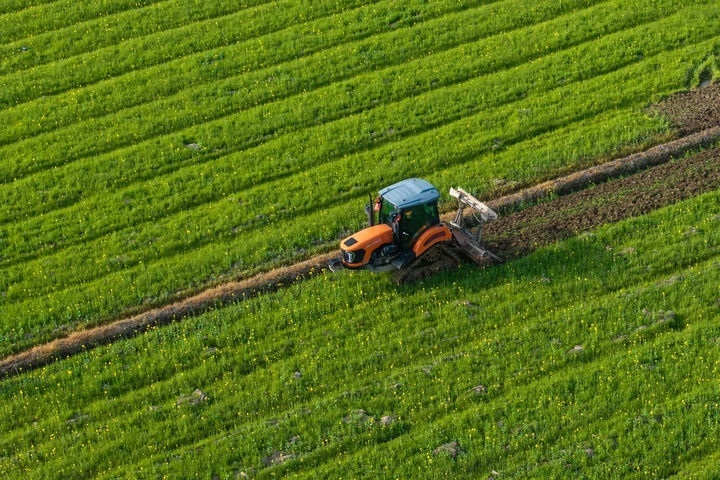 2024年3月19日，在湖南省常德市鼎城區(qū)謝家鋪鎮(zhèn)港中坪村，村民駕駛農(nóng)機(jī)翻耕田地（無人機(jī)照片）。新華社記者 陳思汗 攝