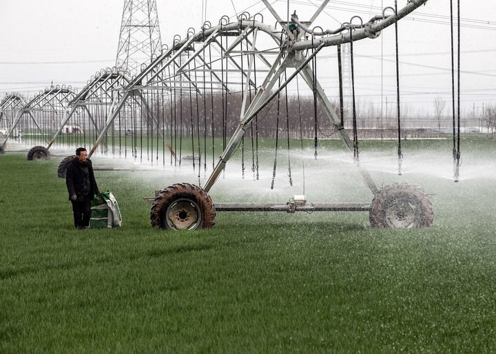 2024年3月18日，在河南省焦作市博愛縣孝敬鎮(zhèn)東原莊村瑞輝家庭農(nóng)場(chǎng)，村民使用全自動(dòng)指針式噴灌機(jī)進(jìn)行澆灌作業(yè)。新華社發(fā)（程全攝）