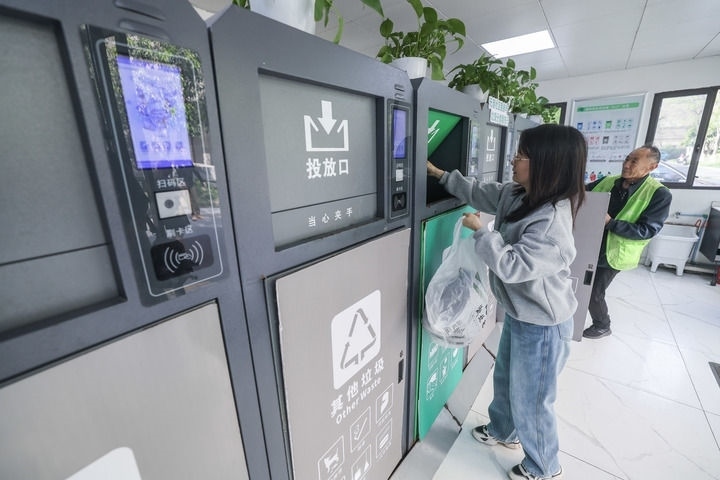 2024年4月10日，在浙江省湖州市吳興區(qū)飛英街道新華府小區(qū)內(nèi)，居民在垃圾分類智能系統(tǒng)的指導(dǎo)下進(jìn)行垃圾分類投放，居民的投放情況將實(shí)時(shí)匯總到智慧服務(wù)平臺(tái)，會(huì)有相應(yīng)的積分獎(jiǎng)勵(lì)。新華社記者 徐昱 攝