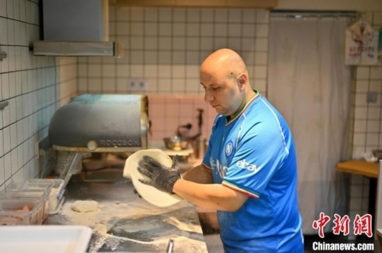 近日，韋榮耀在自家披薩小店內(nèi)忙活。俞靖 攝