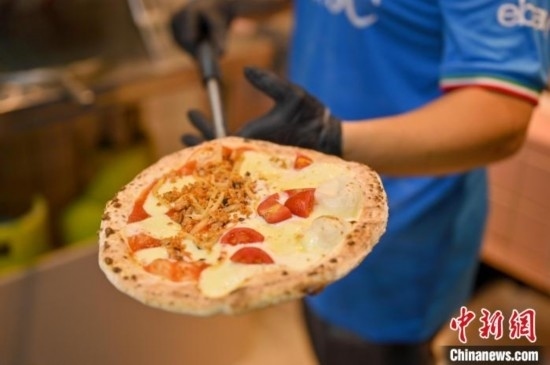 近日，韋榮耀展示他制作的“老友味”披薩。 俞靖 攝