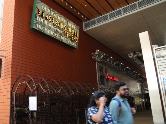 2023年5月29日，人們經(jīng)過美國(guó)紐約曼哈頓的“國(guó)債鐘”?！皣?guó)債鐘”是一個(gè)大型計(jì)數(shù)器，它實(shí)時(shí)更新美國(guó)的公共債務(wù)總額，并顯示出每個(gè)美國(guó)家庭所要負(fù)擔(dān)的數(shù)額。 新華社記者劉亞南攝