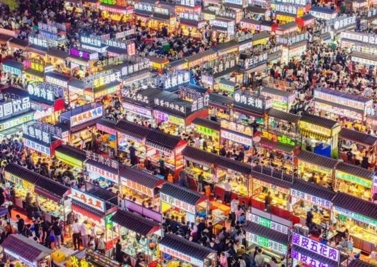 2024年4月21日，人們?cè)诤颖笔≌h小商品夜市品嘗美食（無人機(jī)照片）。新華社發(fā)（武志偉 攝）