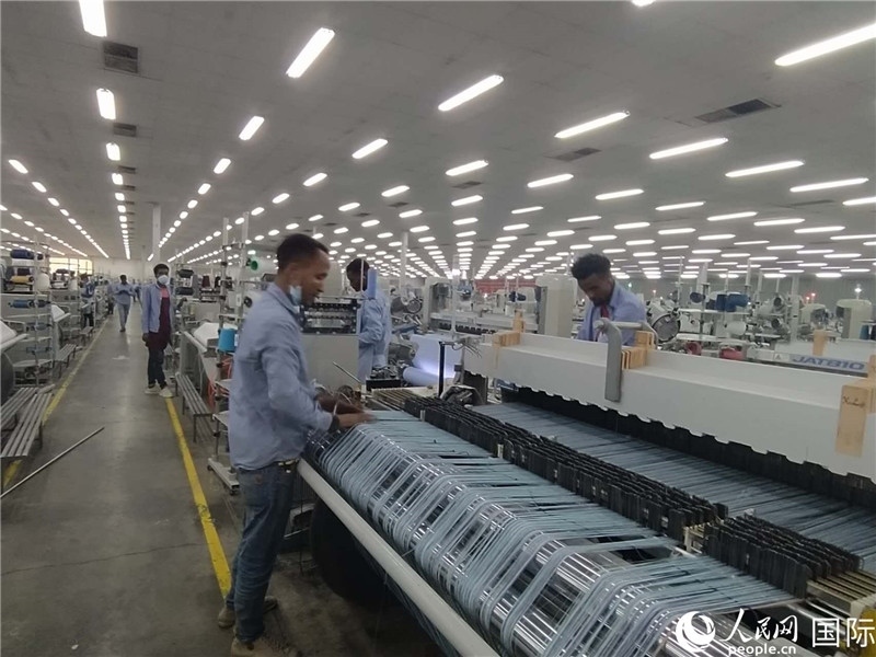 無錫金茂埃塞面料廠車間內(nèi)，當(dāng)?shù)毓と苏谝唤z不茍地作業(yè)。人民網(wǎng)記者 黃培昭攝