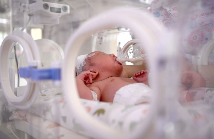 2024年6月1日，在西安國際醫(yī)學中心醫(yī)院新生兒科病房，護士為新生兒喂奶。 新華社記者 劉瀟 攝