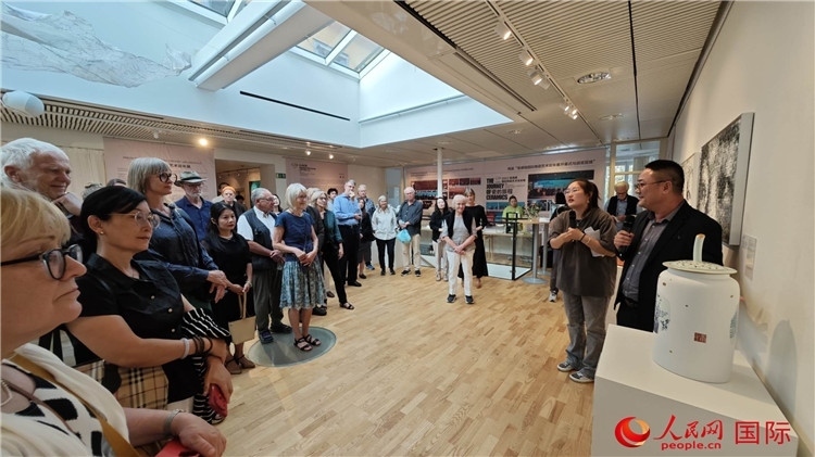 參展人、景德鎮(zhèn)陶瓷大學(xué)美術(shù)學(xué)院副院長(zhǎng)邵長(zhǎng)宗（右一）向來賓介紹參展作品。人民網(wǎng)記者 殷淼攝