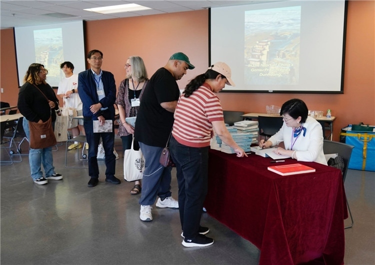 作者顧春芳在活動現(xiàn)場簽名贈書。羅先勇攝