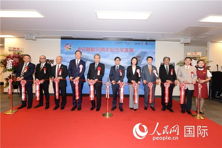 與會嘉賓共同為中日通航50周年紀(jì)念圖片展開幕剪彩。馮學(xué)敏攝