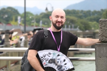 俄羅斯塔斯社執(zhí)行編輯葉夫根尼·扎多羅日內(nèi)在都江堰魚嘴拍照留念。（李佩藺 攝）