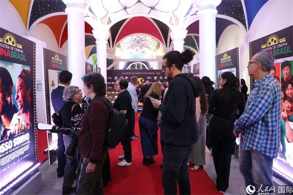為期4天的第三屆中國－巴西電影展期間，來自中巴兩國的14部參展影片受到巴西電影愛好者和社會各界人士好評，圖為當(dāng)?shù)赜^眾在影展舉辦地巴西里約熱內(nèi)盧勞拉—阿爾維姆文化之家的迎賓廳欣賞參展電影海報。 人民網(wǎng)記者 陳一鳴攝
