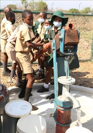 △2021年11月，在津巴布韋南馬塔貝萊蘭省省會關(guān)達的塞農(nóng)多小學(xué)，學(xué)生從中國援建水井里打水。