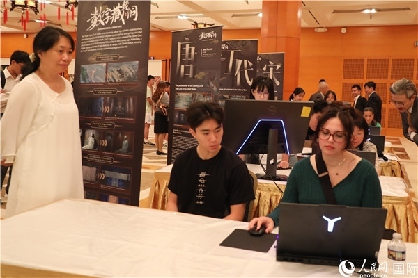 在活動(dòng)現(xiàn)場(chǎng)，當(dāng)?shù)孛癖婓w驗(yàn)“數(shù)字藏經(jīng)洞”云游戲，沉浸式體驗(yàn)敦煌文化。 人民網(wǎng)記者 李志偉攝