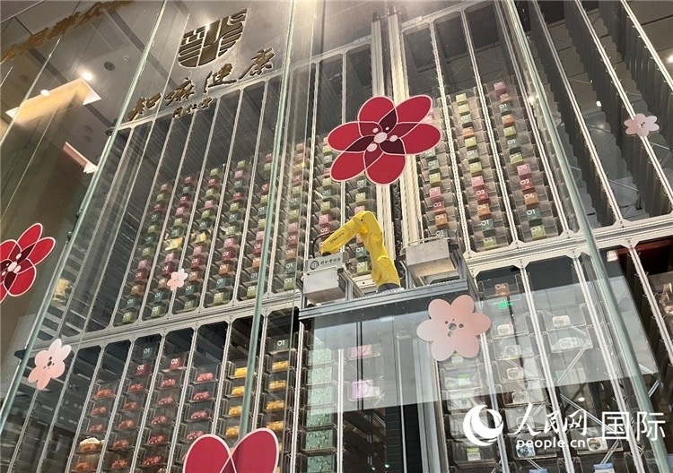 6. 機(jī)械臂正在取貨。（人民網(wǎng)記者陳思 攝）