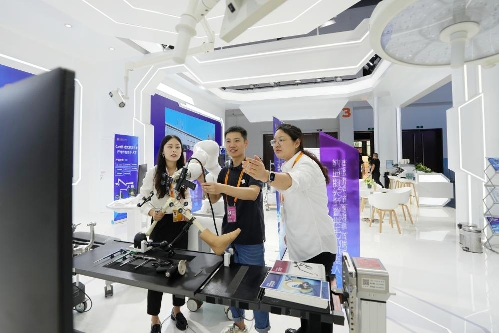 9月11日，一位媒體記者（中）在2024年服貿(mào)會(huì)國(guó)家會(huì)議中心會(huì)場(chǎng)體驗(yàn)北京納通科技集團(tuán)有限公司的膝關(guān)節(jié)置換手術(shù)機(jī)器人。新華社記者鞠煥宗 攝