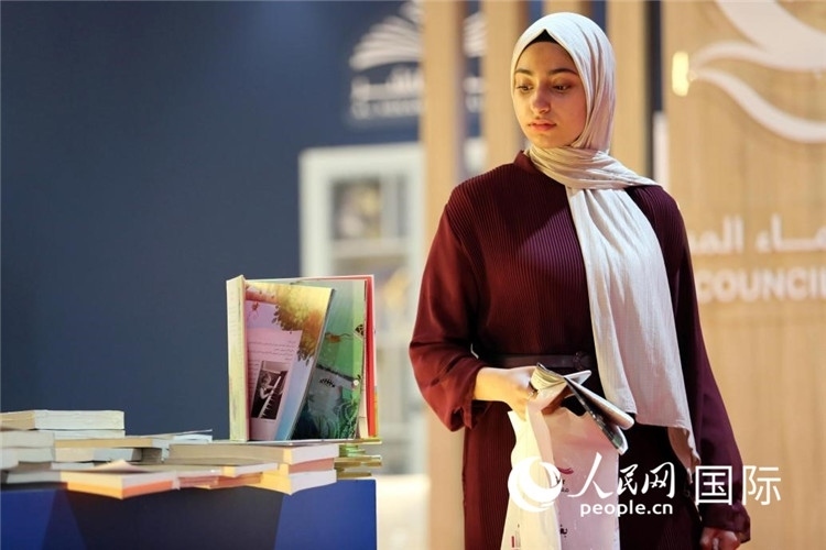 一名女性走過展臺。人民網(wǎng) 奧馬爾·哈利勒攝