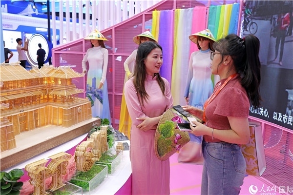 參觀者在東博會越南展區(qū)同工作人員咨詢交談。人民網(wǎng)記者 趙益普攝