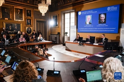 10月8日，在瑞典斯德哥爾摩舉行的2024年諾貝爾物理學(xué)獎公布現(xiàn)場，屏幕顯示獎項(xiàng)得主美國普林斯頓大學(xué)的約翰·霍普菲爾德和加拿大多倫多大學(xué)的杰弗里·欣頓。新華社記者 彭子洋 攝