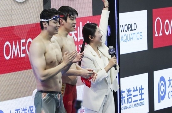  10月18日，汪順（左）和潘展樂在男子100米混合泳決賽后。新華社記者 方喆 攝