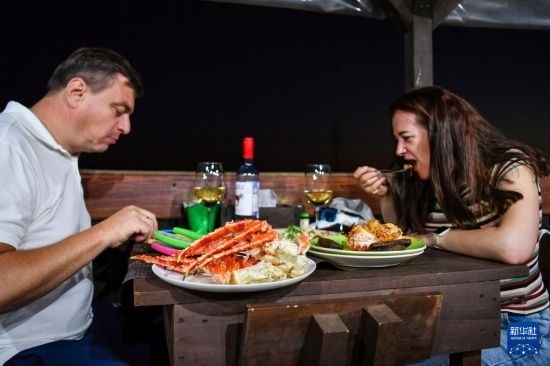 9月2日，食客們在俄羅斯符拉迪沃斯托克的一家餐館品嘗帝王蟹。新華社記者 曹陽 攝