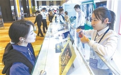 在北京麗澤商務(wù)區(qū)，工作人員（右一）介紹數(shù)字人民幣SIM卡硬錢包。新京報(bào)記者 陶冉攝