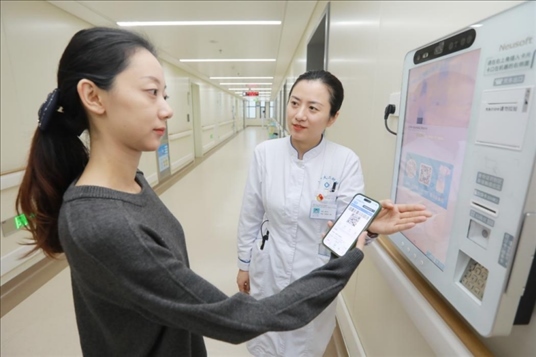 醫(yī)護(hù)人員引導(dǎo)患者在自助機(jī)前辦理自助入院手續(xù)。圖片來源：山東第一醫(yī)科大學(xué)第二附屬醫(yī)院