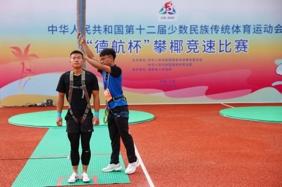 11月23日，工作人員為上海隊選手付樂樂（左）系安全繩。新華社記者 楊植森 攝