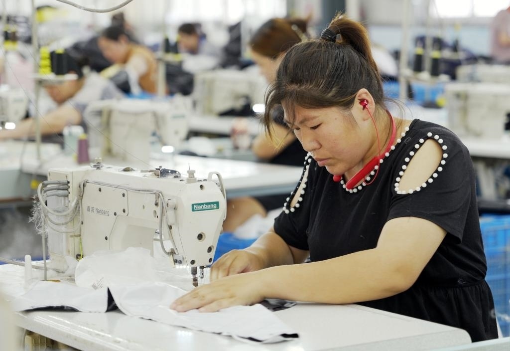 5月20日，村民在李寨村服裝加工廠內(nèi)忙碌。河南省周口市沈丘縣馮營鎮(zhèn)李寨村地處豫東平原。近年來，乘著脫貧攻堅與鄉(xiāng)村振興政策的東風(fēng)，李寨村積極探索產(chǎn)業(yè)發(fā)展模式，通過“龍頭企業(yè)+村集體經(jīng)濟(jì)+農(nóng)戶”的方式，逐漸發(fā)展形成肉牛養(yǎng)殖、設(shè)施農(nóng)業(yè)、服裝加工、康養(yǎng)民宿等產(chǎn)業(yè)，以產(chǎn)業(yè)振興助力鄉(xiāng)村振興。新華社記者 李嘉南 攝
