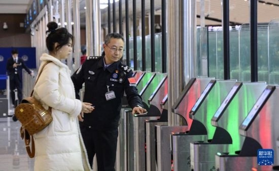 1月2日，大興機(jī)場(chǎng)邊檢站警察指導(dǎo)旅客使用自助出境設(shè)備。新華社記者 李欣 攝