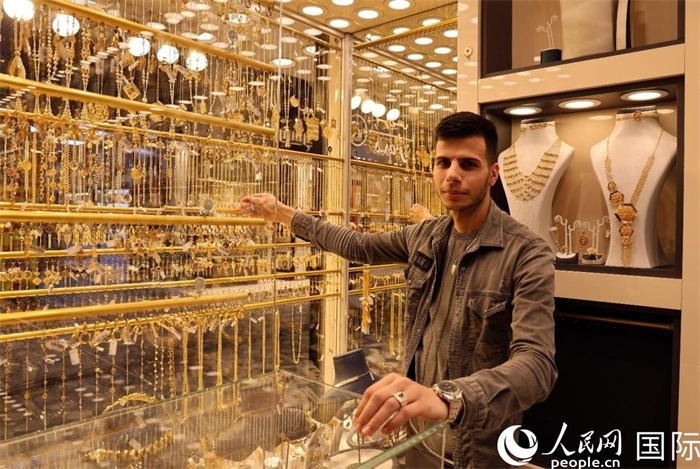 一名銷售員展示黃金飾品。人民網(wǎng) 伊納斯·易卜拉欣攝