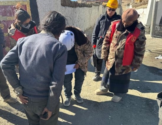 1月13日，次旺（右一）陪同工作組走訪村莊，評估房屋受損程度。新華社發(fā)