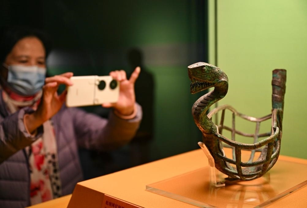 1月14日，觀眾在上海博物館蛇年迎春展拍攝展品蛇綱網(wǎng)狀銅器。新華社發(fā)（陳浩明攝）