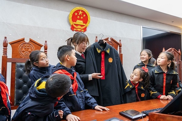 圖②：干警向同學們介紹法袍。