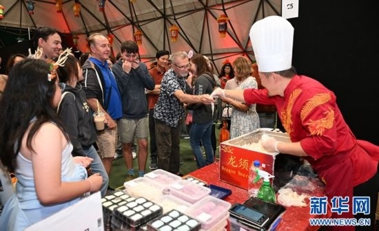 圖為游客在燈節(jié)現(xiàn)場購買小吃。（圖片由奧克蘭中國文化中心提供）