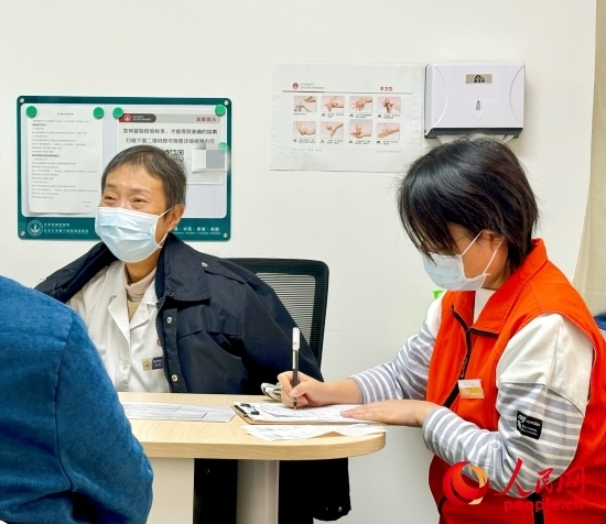 秦苑（中）接診患者。人民網(wǎng)記者 金慧慧攝