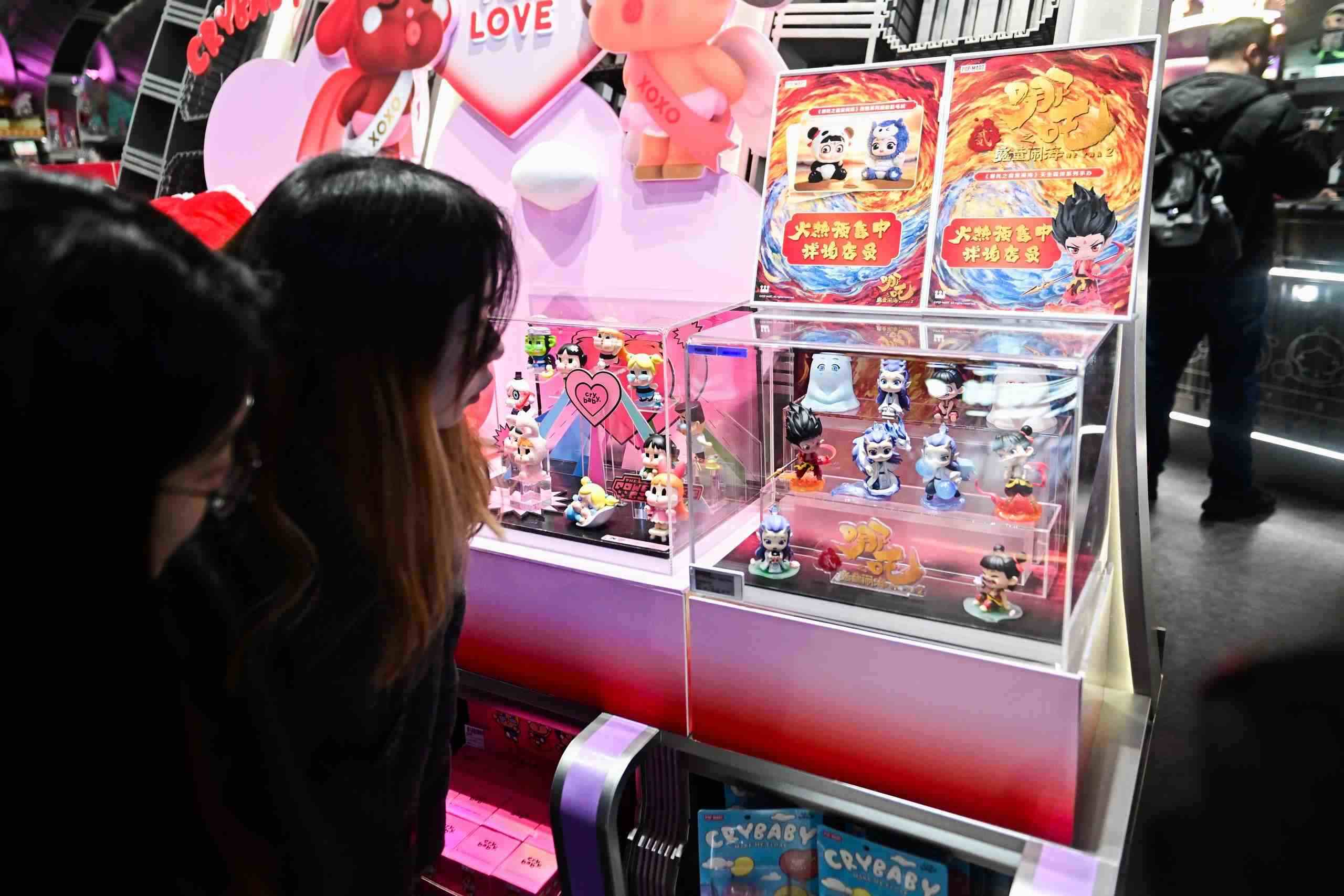 △2025年2月22日，上海，市民在圍觀《哪吒之魔童鬧?！废嚓P(guān)手辦盲盒。