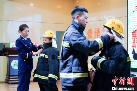 圖為學(xué)生們現(xiàn)場穿戴消防頭盔和戰(zhàn)斗服。中新社記者 趙宇航 攝