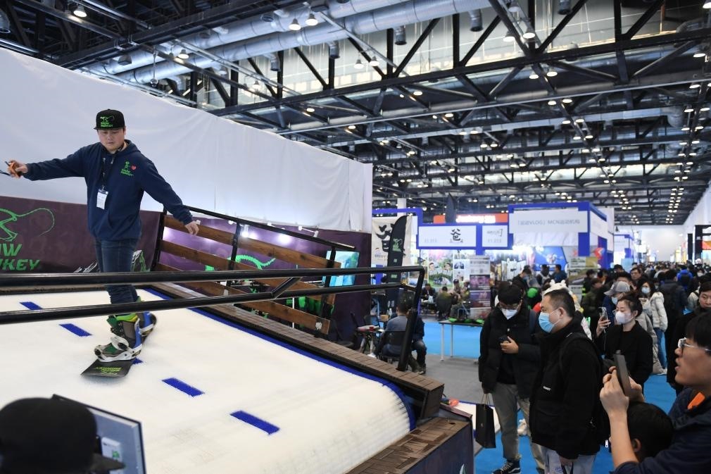 2023年2月11日，參觀者在展會上了解一款模擬滑雪設(shè)備。當(dāng)日，2023亞洲運(yùn)動用品與時尚展在國家會議中心拉開帷幕。新華社記者 張晨霖 攝