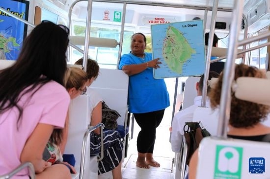 3月15日，一名導(dǎo)游在游艇上為游客介紹塞舌爾拉迪格島。新華社記者 董江輝 攝