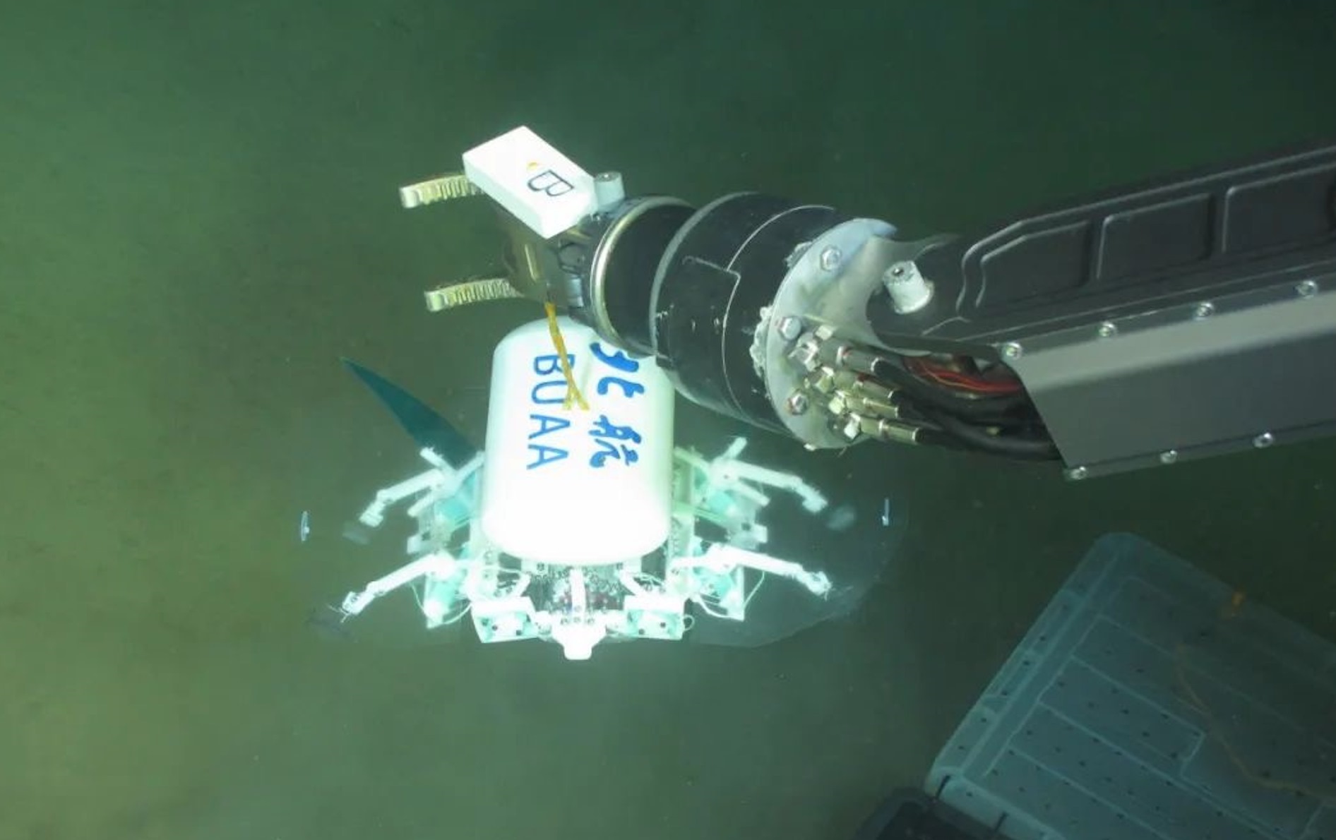 科研人員利用機(jī)械臂將北航深海小型機(jī)器人投于馬里亞納海溝。校方供圖