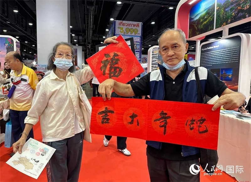 2025蛇年春節(jié)，泰國市民展示他們領(lǐng)到的華人手寫春聯(lián)。人民網(wǎng)記者 簡承淵攝