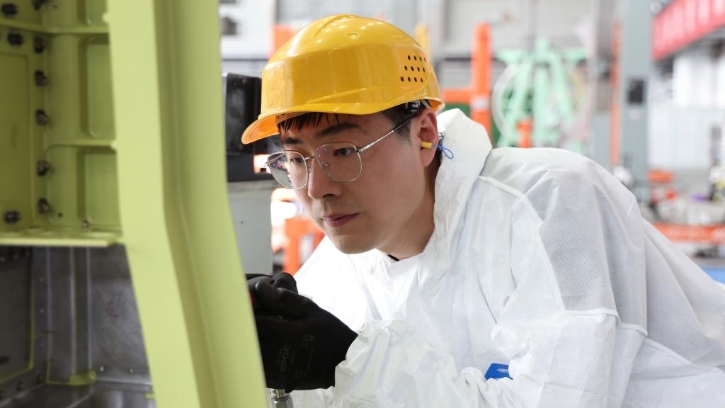 在中國(guó)航空工業(yè)集團(tuán)成飛車(chē)間內(nèi)，飛機(jī)鉚裝鉗工首席操作技師馮攀龍正在工作。（新華社發(fā)）