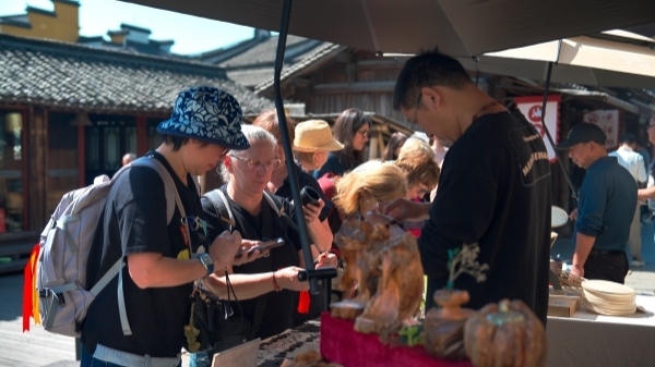 “五一”期間，游客正在烏鎮(zhèn)“水鄉(xiāng)碼頭”挑選購買文創(chuàng)產(chǎn)品。受訪者供圖