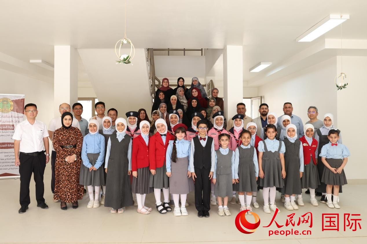 中國(guó)電建員工與阿爾穆塔?阿里卡特國(guó)際學(xué)校的師生及政府官員等合影。人民網(wǎng)記者 薛丹攝